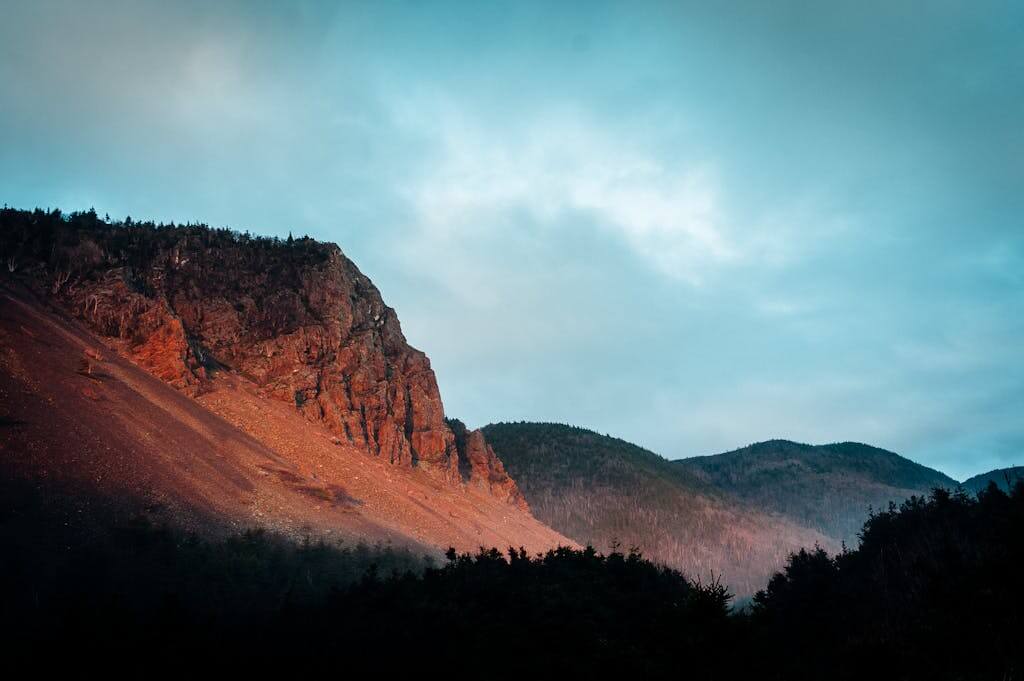 Vibrant landscape of red rock formations against a blue sky in Nova Scotia, Canada.